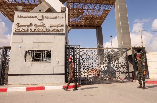 Members of Palestinan security forces stand guard at the closed off Rafah border crossing to Egypt in the southern Gaza Strip, on August 23, 2021. - Egypt has told Gaza authorities it will close the Rafah border crossing from August 23, a spokesman for the Palestinian enclave's Hamas government said. (Photo by SAID KHATIB / AFP)