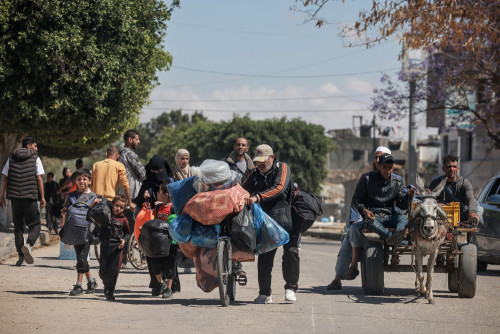 Displaced Palestinians in Rafah in the southern Gaza Strip carry their belongings as they leave following an evacuation order by the Israeli army on May 6, 2024.