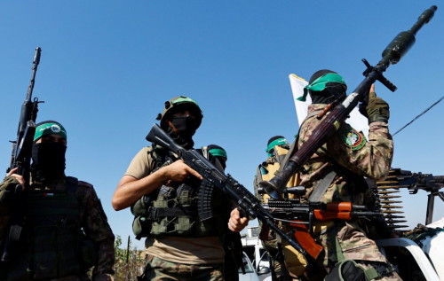 Palestinian fighters from the armed wing of Hamas take part in a military parade to mark the anniversary of the 2014 war with Israel, near the border in the central Gaza Strip, July 19, 2023. REUTERS/Ibraheem Abu Mustafa