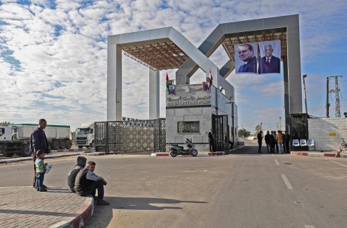 Portraits of Egyptian President Abdel Fattah al-Sisi and Palestinian leader Mahmud Abbas hang at the Rafah border crossing with Egypt on November 1, 2017.  Hamas handed over control of the Gaza Strip's border with Egypt to the Palestinian Authority today, a first key test of a Palestinian reconciliation agreement agreed last month, an AFP journalist said. / AFP PHOTO / SAID KHATIB