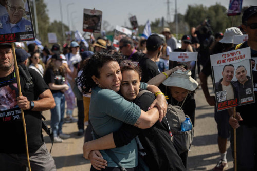 KIBBUTZ SA’AD, ISRAEL - FEBRUARY 28, 2024 - (Left to right) Meirav Leshem Gonen, whose daughter Romi is being held hostage in Gaza, embraces Sharon Alony Cunio, who was kidnapped and released from captivity along with her two children and whose husband David remains hostage in Gaza, as the march to Jerusalem passes Kibbutz Sa’ad in southern Israel on February 28, 2024. Amid fraught negotiations between Israel and Hamas over conditions for a ceasefire, the families of the hostages held a four-day march from areas attacked on October 7 in southern Israel to Jerusalem to keep attention focused on the plight of their loved ones still in captivity and to further pressure the Israeli government to secure to a deal that would release them. (Tamir Kalifa for NPR)